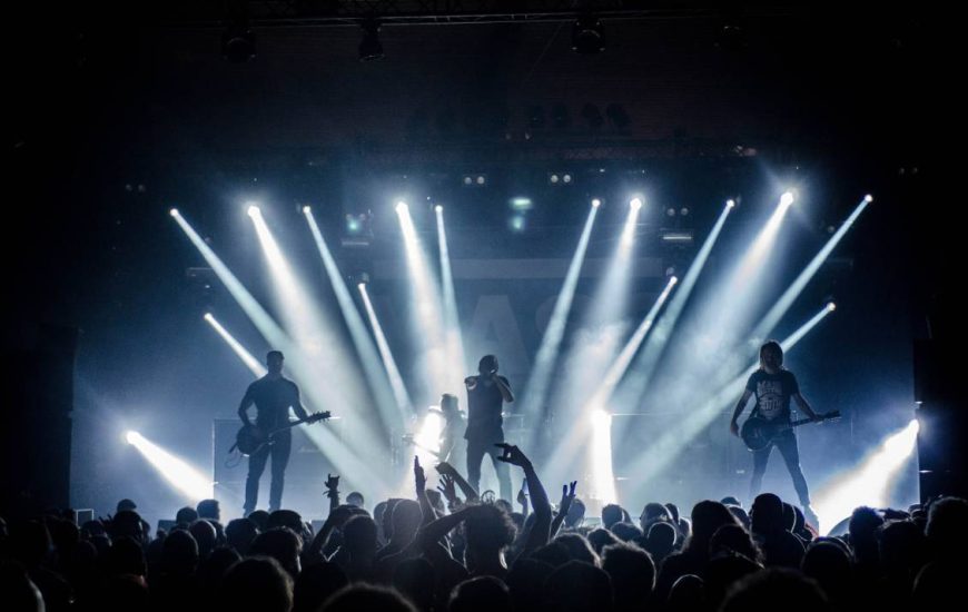 pohled na pódium z hlediště na hrající rockovou kapelu