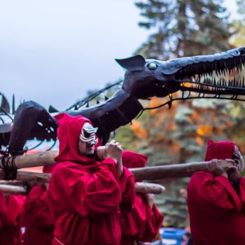 lidé nesou kovového draka