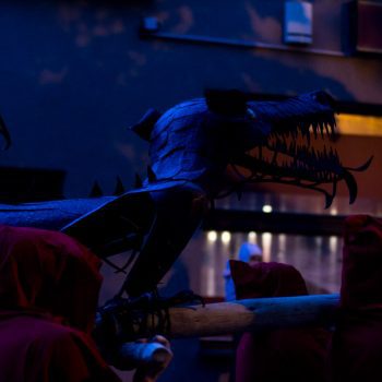 lidé nesou kovového draka