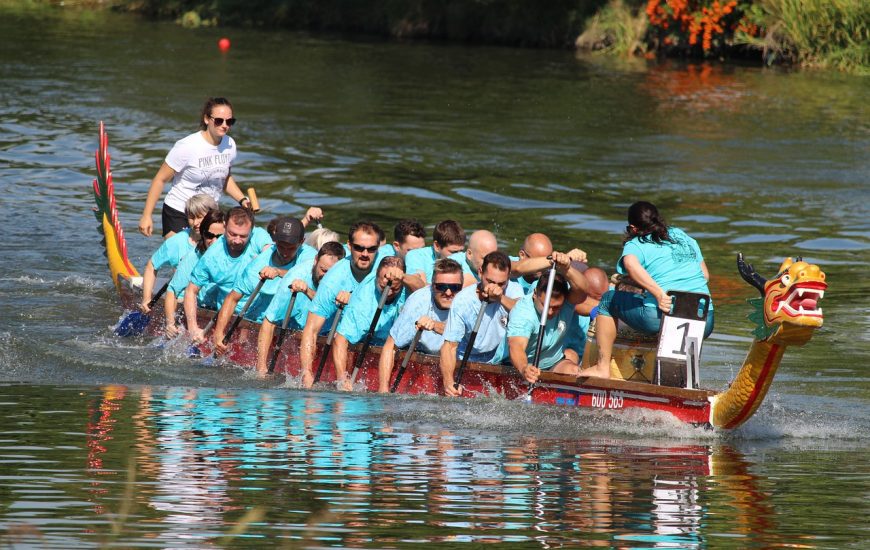 lidé jedou na dračí lodi