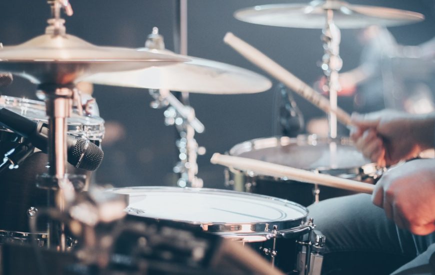 člověk hrající na bicí soupravu