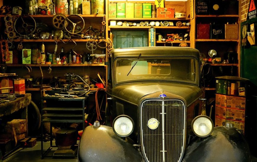 auto veteran zaparkované v garáži v okolí spousta náhradních dílů