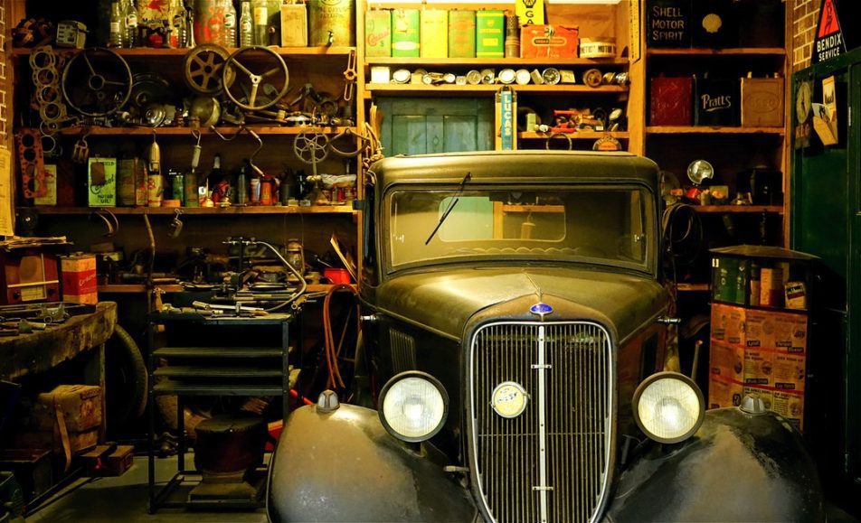 auto veteran zaparkované v garáži v okolí spousta náhradních dílů