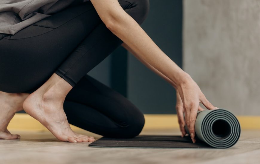 žena rozbalující podložku na dvičení